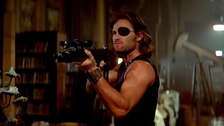 Escape From New York/Бягство от Ню Йорк
Помните ли го Кърт Ръсел?  Последните години се позагуби, но през 80-те и началото на 90-те той е една от най-горещите екшън звезди на Холивуд. Кариерата му започва далеч преди това, още като тийнейджър, но истинският му пробив идва с нискобюджетния футуристичен “Бягство от Ню Йорк”. Той става толкова успешен, че много хора и до днес свързват превръзката за очи със Снейк Плискин, а не с еднооките пирати.
Историята е класически постакалиптичен разказ за тогавашното бъдеще през 1997 г, когато остров Манхатън е превърнат в гигантски затвор за най-ужасните престъпници. Американският президент е похитен, а единственият човек, който може да го освободи е Снейк Плискин.