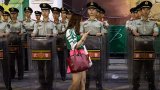 Ултарс фенка на Пекин Гуоан минава пред охраната на стадиона след мач с Тиендзин през юни 2015 г.