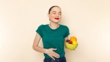 front-view-young-attractive-female-dark-green-shirt-holding-plate-with-fruits-with-smile