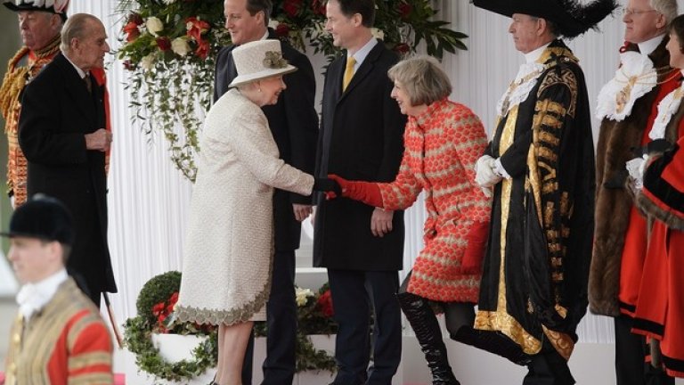 С лачени чизми и червено палто пред кралица Елизабет II