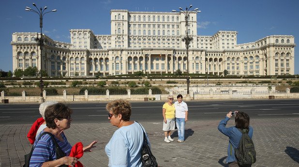 Туристи се снимат пред парламента на Румъния, който се помещава в Народния дворец, построен от Чаушеску в прослава на неговия режим	