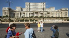 Туристи се снимат пред парламента на Румъния, който се помещава в Народния дворец, построен от Чаушеску в прослава на неговия режим	