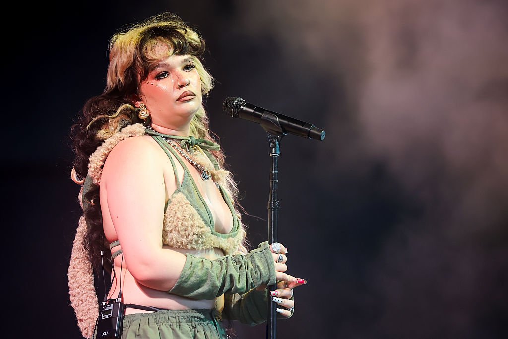 Лола ЯнгЛола Янг излезе на сцената с озадачаващ за пролетното време аутфит с пухкава качулка и пухкаво горнище върху първото горнище на бански. Надолу пък следва безформен панталон с ниска талия. И всичко това – във войнишко зелено и придружено с фрапантен грим. Може би младата певица е трябвало да изглежда небрежно, само че резултатът е далеч от търсения.