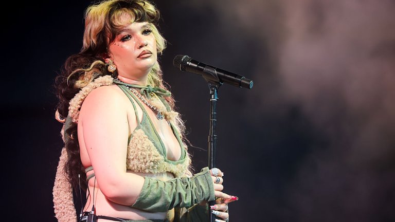 Лола ЯнгЛола Янг излезе на сцената с озадачаващ за пролетното време аутфит с пухкава качулка и пухкаво горнище върху първото горнище на бански. Надолу пък следва безформен панталон с ниска талия. И всичко това – във войнишко зелено и придружено с фрапантен грим. Може би младата певица е трябвало да изглежда небрежно, само че резултатът е далеч от търсения.