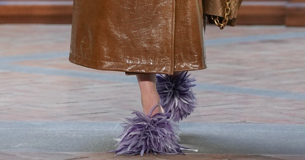 Мекота, която не е сантиментална
Косъмът и пухкавите елементи се появяват не за украса, а за настроение и комфорт. Тези детайли носят усещане за топлина и интимност, без да превръщат обувките в домашен аксесоар. Напротив – използвани премерено, те добавят характер и визуален контраст към по-груби силуети и тежки подметки.