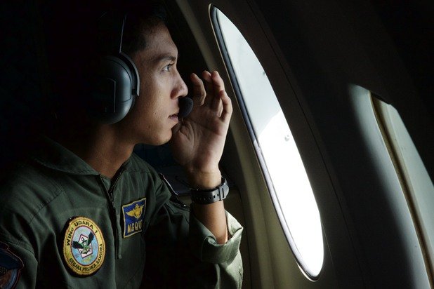 Военен пилот от Индонезийските ВВС по време на огледа в търсене на следи от самолета.