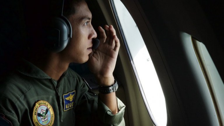 Военен пилот от Индонезийските ВВС по време на огледа в търсене на следи от самолета.