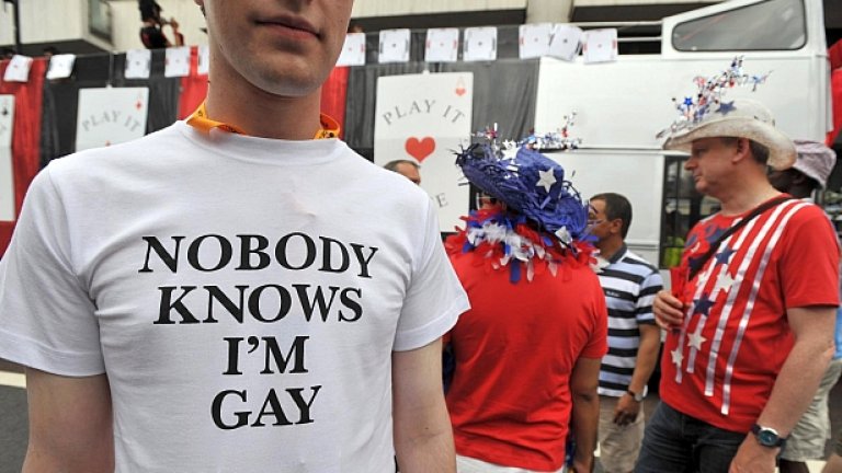 участник в британски гей парад, на чиято фланелка пише "Никой не знае, че съм гей"