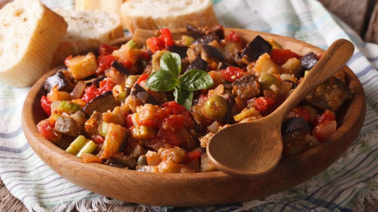 КапонатаХубавото на капонатата е, че всичко се случва в един съд. В дълбока тенджера с по-дебело дъно запържваме голяма глава лук и няколко скилидки чесън. Като омекнат, прибавяме две червени и две зелени чушки, нарязани на кръгчета. Когато и те омекнат, слагаме два патладжана на кубчета и 500 грама домати от консерва.
Подправяме със сол, пипер и щедро количество риган и оставяме да се сгъсти като яхния. След това прибавяме две шепи маслини – цели или грубо нарязани – и супена лъжица каперси. Оставяме за малко на котлона да си поеме вкусовете и сервираме. Капонатата е вкусна и студена на другия ден.