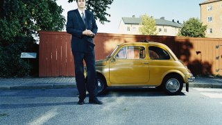 висок мъж  с малка кола