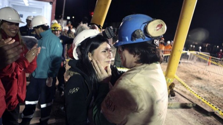 Един от спасените чилийски миньори Осман Арая прегръща жена си след излизането си от преизподнята под земята