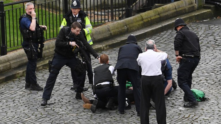 Полицай държи на прицел атентатора от Лондон, неутрализиран от охранители на парламента след нападението. Как се случи всичко - вижте в галерията. 