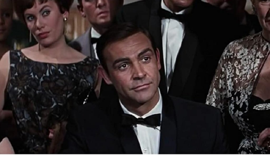 За легендарния агент 007
Светът го помни като актьора, дал начало на успешната поредица за британския супершпионин Бонд. Но тъй като играе в общо седем филма от поредицата и хората го асоциират предимно с този му образ, това омръзва на Конъри. Затова и рядко в интервютата си говори за него. Въпреки това признава, че са били "вълнуващи и забавни" години.
"Имаше добри истории, хубави момичета и интригуващи дестинации", казва пред IndieWire през 2002 г. На въпрос на какво според него се дължи успехът на "Доктор Но" от 1962 г., той отговаря, че вероятно е заради това, че е вид "изход от мрачните драми от края на 50-те".
"Беше освежаващ и имаше собствен стил. Освен това ключовата съставка беше хуморът, който балансираше добре с постоянната заплаха от смърт. А хуморът липсва в книгите на самия Флеминг", казва Конъри. Въпреки това се заема с проекта не на шега, а съвсем насериозно. "Героят ми трябва да изглежда достатъчно внушителен и силен, за да направи всичко това, или да изглежда достатъчно възрастен", споделя актьорът.