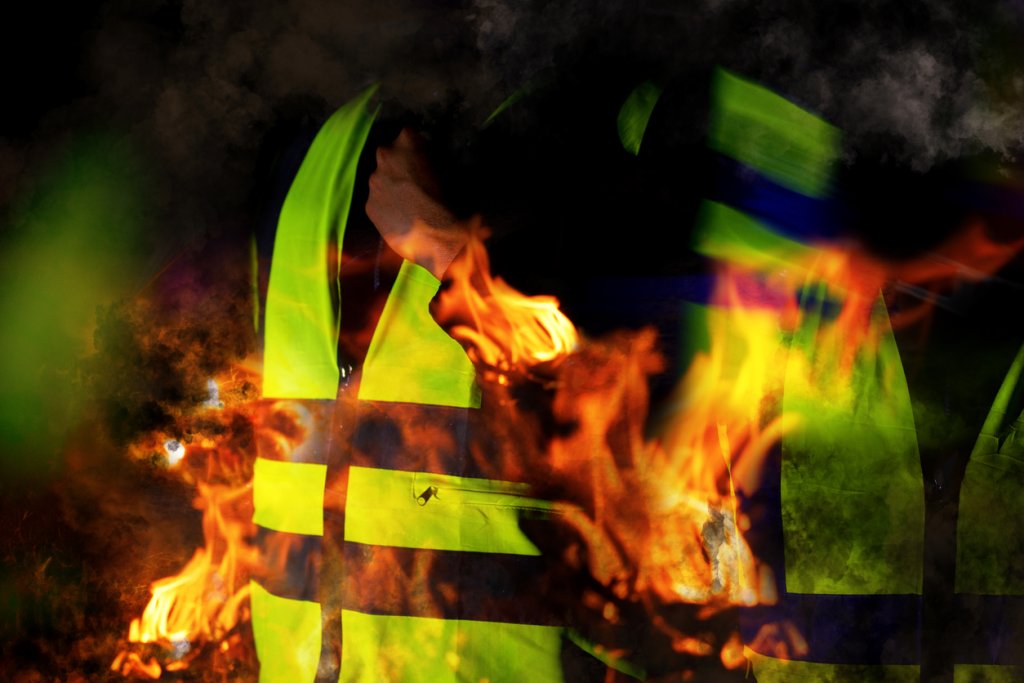 Yellow vests of protest with fire in France on black background