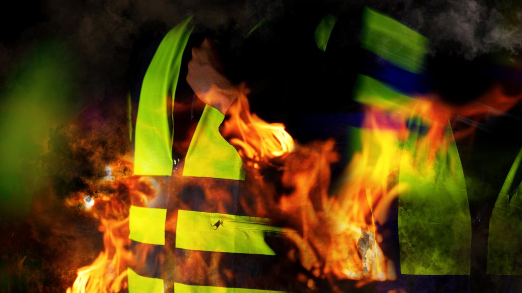 Yellow vests of protest with fire in France on black background