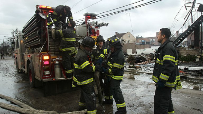 Пожарникари вадят хора от наводнените къщи