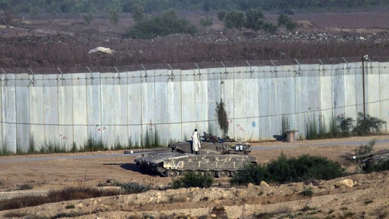 Израелски войник се моли върху танк в близост до стената, която разделя Израел и ивицата Газа, рано сутринта на 18 юли