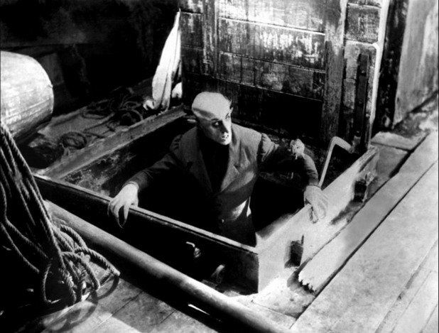 14. Макс Шрек – "Носферату" Едно от най-влиятелните актьорски изпълнения в нямото кино е дефиниращата жанра поява на Макс Шрек в ролята на вампир. В "Носферату" той играе граф Орлок, плашещо и отблъскващо създание, създадено на идеите на Брам Стокър.
Този германски актьор е иновативен изпълнител, който се трансформира във вампир чрез наслагване на грим и употреба на протези за преувеличаване на естествения му измършавял вид, така че да изглежда като плашещ, нечестив символ на ужаса.
Най-добрите изпълнения във филма са в сцената, където Хътър порязва пръста си, докато вечеря с Орлок. Наблюдавайки как кръвта изтича от Хътър, Макс Шрек развива безумната кръвожадност на Носферату чрез напрегнат, смущаващ поглед и странни, бързи движения към жертвата му, в крайна сметка облизва порязания пръст преди основното ястие