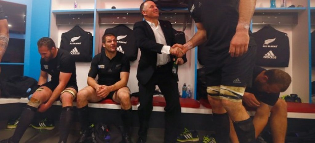Новозеландският премиер Джон Кий изглежда като хлапе пред 203-сантиметровия Сам Уайтлок от тима на All Blacks... Нова Зеландия стана световен шампион в ръгбито, а премиерът влезе да поздрави тима в съблекалнята.