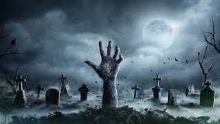 Zombie Hand Rising Out Of A Graveyard In Spooky Night