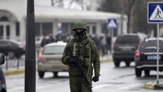 An armed man patrols at the Simferopol airport in the Crimea region