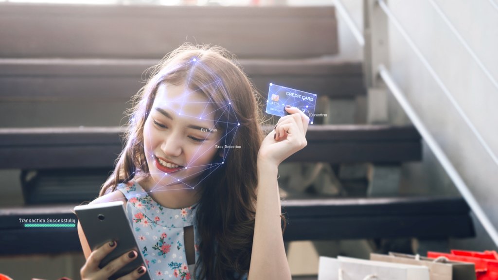 Face scan adult asian woman for shopping online with mobile phone.