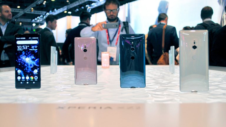 Sony XZ2 и XZ2 Compact 
Фактът, че Sony най-после имат нов дизайн при флагманите си е труден за вярване, но те са тук, за да останат. Заоблен заден панел, по-малки разстояния между екрана и панела и подвеждане по тренда на липсващ 3.5 мм жак е най-важното, което трябва да знаете. Този път компанията не се престарава с 4k екран, и XZ2 идва с 5.7 инча FHD+ (2160 x 1080) със съотношение на страните 2:1. За сметка на това телефонът поддържа HDR и оптимизира обикновената картина за него. 
Отзад камерата е преместена една идея по-долу, а сензорът за пръстовия отпечатък е преместен от бутона за изключване към свое собствено място под камерата, почти в центъра на телефона (което може и да е малко неудобно за свикване). 
Камерата на XZ2 също е подобрена спрямо миналогодишния XZ Premirum и тук имаме 960fps slow motion видео, което обаче вече е в 1080p резолюция. Отново е благодарение на DRAM вградена памет. Сензорът е 19 мегапиксела и вече при заснемането на 4k видео поддържа и HDR цветове. В допълнение можете да правите и 3D селфи версия на себе си, която да качвате в социалните мрежи. 
За сметка на липсващия жак за слушалки, телефонът дори вибрира леко спрямо това, което слушате. 
Sony XZ2 естествено идва с най-новия мощен процесор Snapdragon 845 и 4GB RAM. 
По-малкият XZ2 Compact се предлага с по-орязани функционалности и с пластмасов панел, но в традицията на Sony пази същия добър процесор и камерата, както при флагмана. За съжаления батерията му е по-малка. 
Все още не е ясно кога ще започне продажбата на двата модела в България, но едва ли ще се забави твърде много.