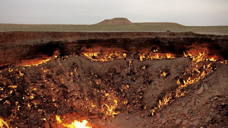 Вратата към Ада в Туркменистан

Когато през 1971 г. екип съветски учени започва пробоиви за извличане на природен газ край туркменистанското село Дарваза в пустинята Каракум, едва ли някой очаква, че мястото скоро ще се превърне в своеобразна "порта към ада". Малко под мястото на пробив има голяма пещера, пълна със земен газ, който се възпламенява и създава това уникално природно явление. Постоянният поток на метан към дупката прави огънят вечен, а районът придобива демонично очарование.