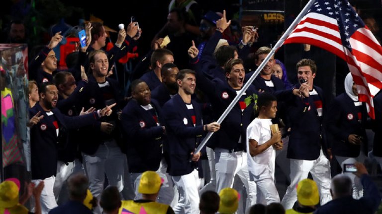 Завърналият се плувец и олимпийска легенда Майкъл Фелпс поведе американската делегация със знамето в ръка
