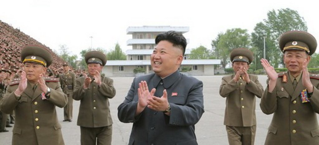 North Korean leader Kim Jong Un applauds during a photo session with soldier-builders who took part in building the workers' hostel of Kim Jong Suk Pyongyang Textile Mill