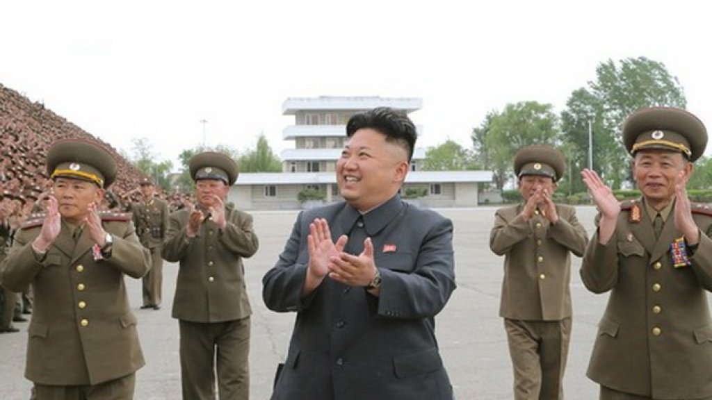 North Korean leader Kim Jong Un applauds during a photo session with soldier-builders who took part in building the workers' hostel of Kim Jong Suk Pyongyang Textile Mill