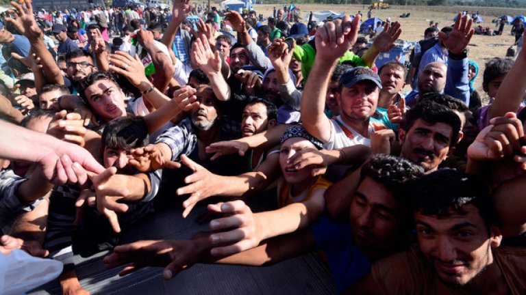 Мигранти чакат помощи от "Каритас" на границата между Гърция и Македония. Вълната от хиляди новопристигнали бежанци не намалява.