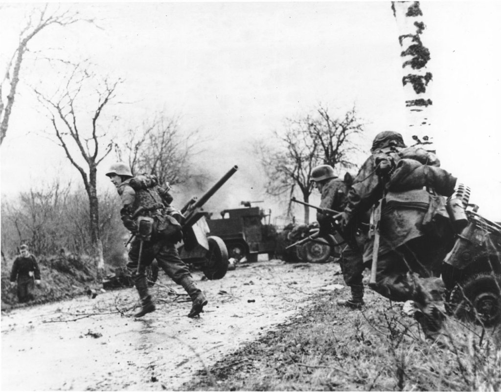 GERMAN_TROOPS_ADVANCING_PAST_ABANDONED_AMERICAN_EQUIPMENT