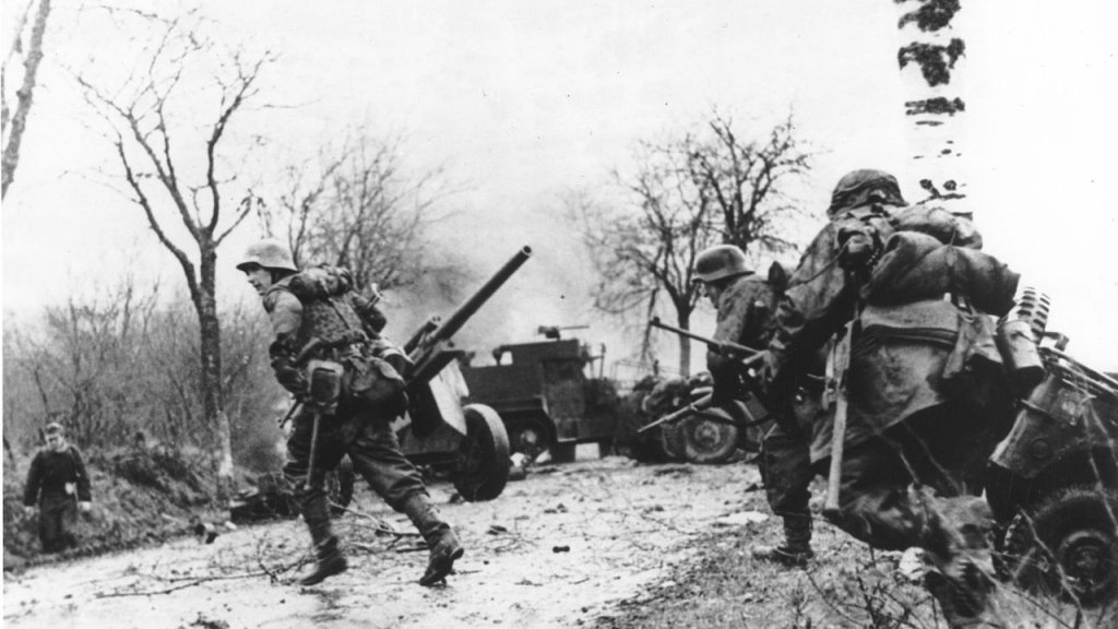 GERMAN_TROOPS_ADVANCING_PAST_ABANDONED_AMERICAN_EQUIPMENT