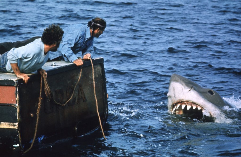 4. Jaws / "Челюсти" - Стивън Спилбърг (1975 г.) 
Добрият филм на ужасите може да даде на публиката няколко наистина добри стряскания и дори да ги накара след това да спят на запалена лампа. Но малцина са променили толкова фундаментално човешкото поведение, както го направи „Челюстите“, принуждавайки милиони да се отдръпнат от водата и създавайки дълбок страх към акулите. Акулата във филма на Спилбърг не е просто животно, тя е праисторическа брутална сила, властелин на океаните, който може да отнеме живота ти във всеки един момент.