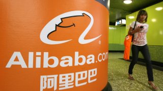 A pedestrian walks past Alibaba.com adve