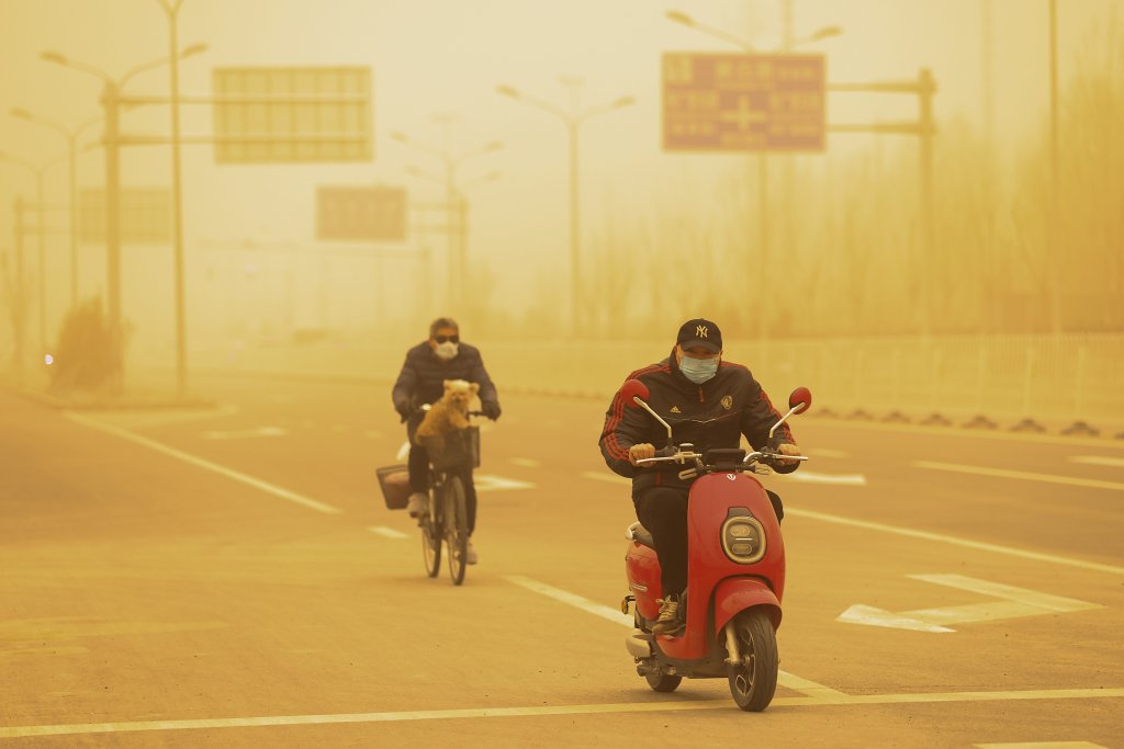 Силна прашна буря направи небето в Пекин оранжево (снимки)