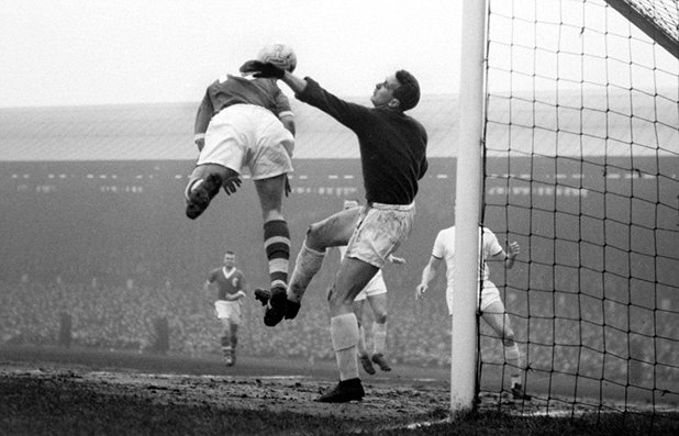 Първата снимка ни пренася в началото на 1960-а на "Анфийлд". Вратарят на Юнайтед Хари Грег, оцелял от трагедията в Мюнхен две години по-рано, се опитва да предотврати опасност в наказателното поле. Юнайтед печели с 3:1 в среща от 4-ия кръг на ФА къп с попадение на Уорън Брадли и два гола на Боби Чарлтън. Още в следващия кръг Юнайтед губи от Шефилд Уензди