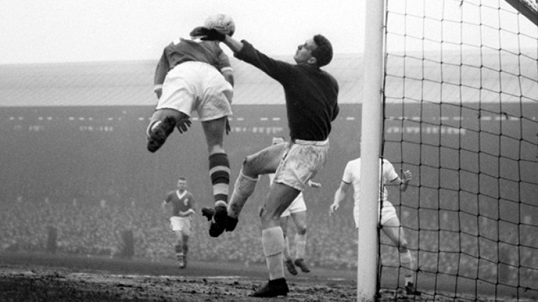 Първата снимка ни пренася в началото на 1960-а на "Анфийлд". Вратарят на Юнайтед Хари Грег, оцелял от трагедията в Мюнхен две години по-рано, се опитва да предотврати опасност в наказателното поле. Юнайтед печели с 3:1 в среща от 4-ия кръг на ФА къп с попадение на Уорън Брадли и два гола на Боби Чарлтън. Още в следващия кръг Юнайтед губи от Шефилд Уензди
