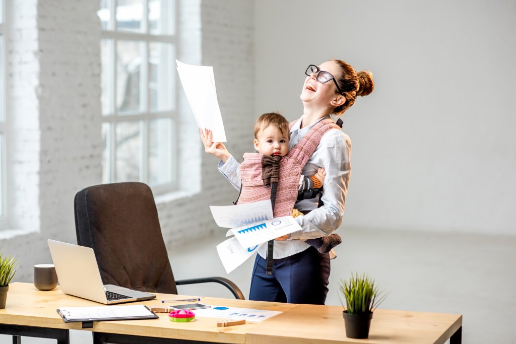 Businesswoman with her baby son working with documents at the office