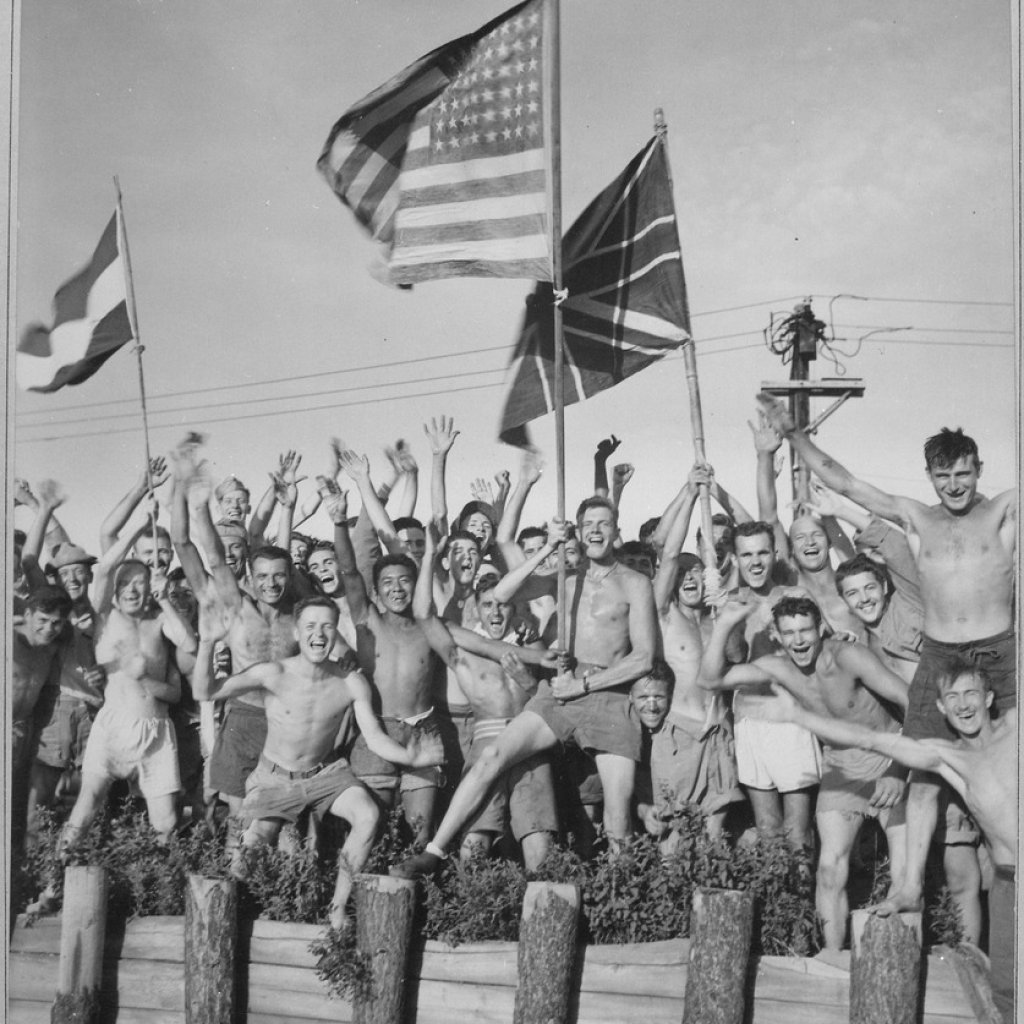 lossy-page1-837px-Gaunt_allied_prisoners_of_war_at_Aomori_camp_near_Yokohama_cheer_rescuers_from_U.S._Navy._Waving_flags_of_the_United..._-_NARA_-_520992.tif