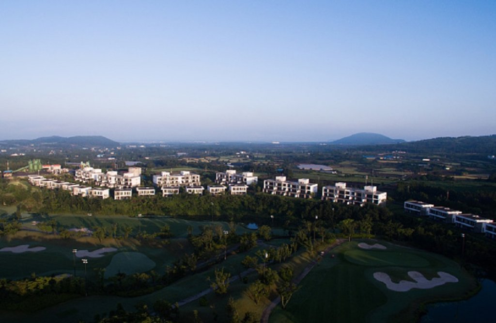 The Teddy Palace apartments, developed by Jeju China Castle Ltd. (JCC), stand next to a golf course in this aerial photograph taken above Seogwipo in Jeju, South Korea, on Sunday, June 28, 2015. South Korea?s 15 trillion won ($13.3 billion) extra budget w