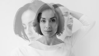 Multiple identities. Close-up photo of a young pretty brunette girl who is looking in the camera while internally suffering from a dissociative identity disorder. Double exposure.
