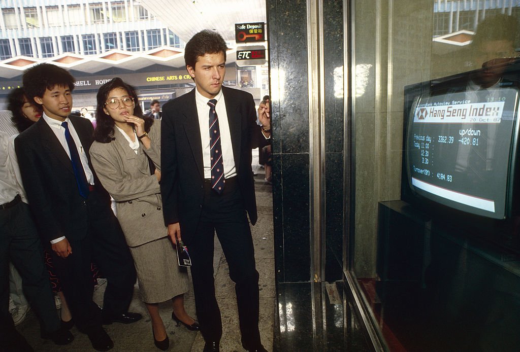 Black Monday. Business people watch a TV monitor in a bank