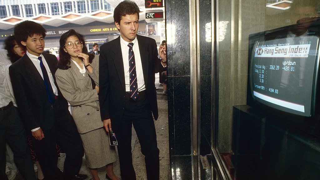Black Monday. Business people watch a TV monitor in a bank