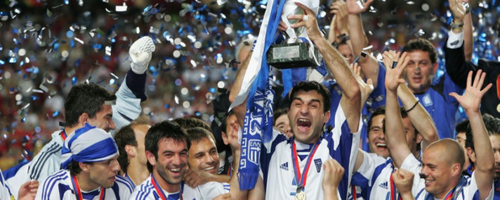 2. Европейската титла на Гърция през 2004-а
Гърция дойде от нищото, за да шокира футболния свят. Елините победиха всички по пътя си, а накрая потопиха португалците в сълзи, побеждавайки ги с 1:0.
Ангелос Харистеас вкара победния гол, а дори звездите Кристиано Роналдо и Луиш Фиго не намериха път към вратата на Гърция.

