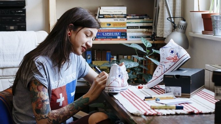 Тя е художник с шарени татуировки и огромна усмивка.