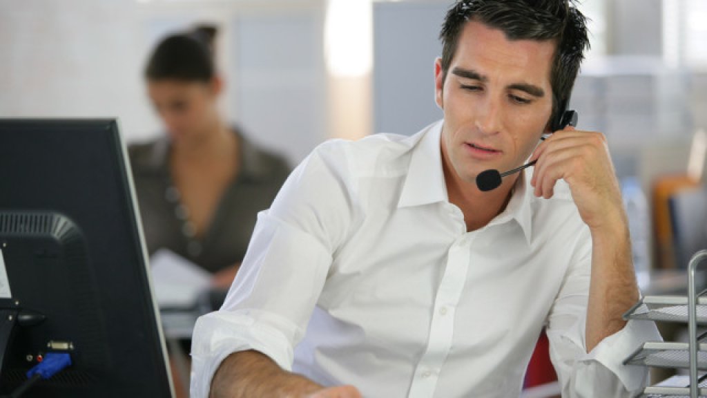 Young man telemarketer in call center