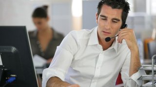 Young man telemarketer in call center