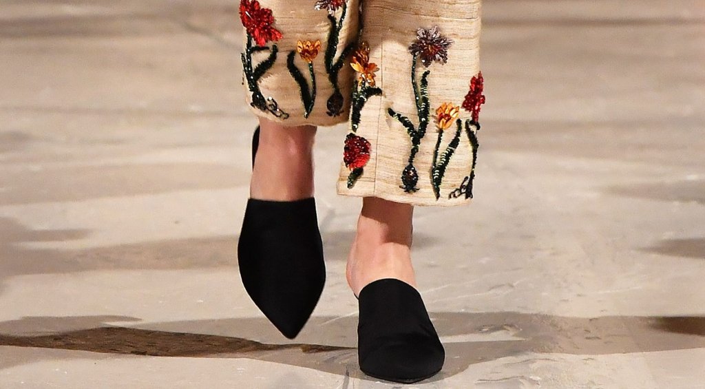 Официалните, но и лежерни лоуфъри
Ако до вчера свързвахте лоуфърите единствено с есенната униформа на софийските хипстъри или с гардероба на дядо ви, когато отива до пощата, време е за ъпдейт. Пролетта на 2026-а реши, че е крайно време да освободи петите ни от робството на кожата и резултатът е тук: retro clog vibe среща класическата обувка в нещо, което прилича на хибрид между луксозен чехъл и официален лоуфър.
Този „рефреш“ всъщност е голямата новина от ревютата на Виктория Бекъм и Bottega Veneta. Дизайнерите ни убеждават, че сгънатата пета и силуетът „без гръб“ са точно това, от което се нуждаем, за да изглеждаме хем излъскани за офиса, хем достатъчно лежерни за аперитив на слънце